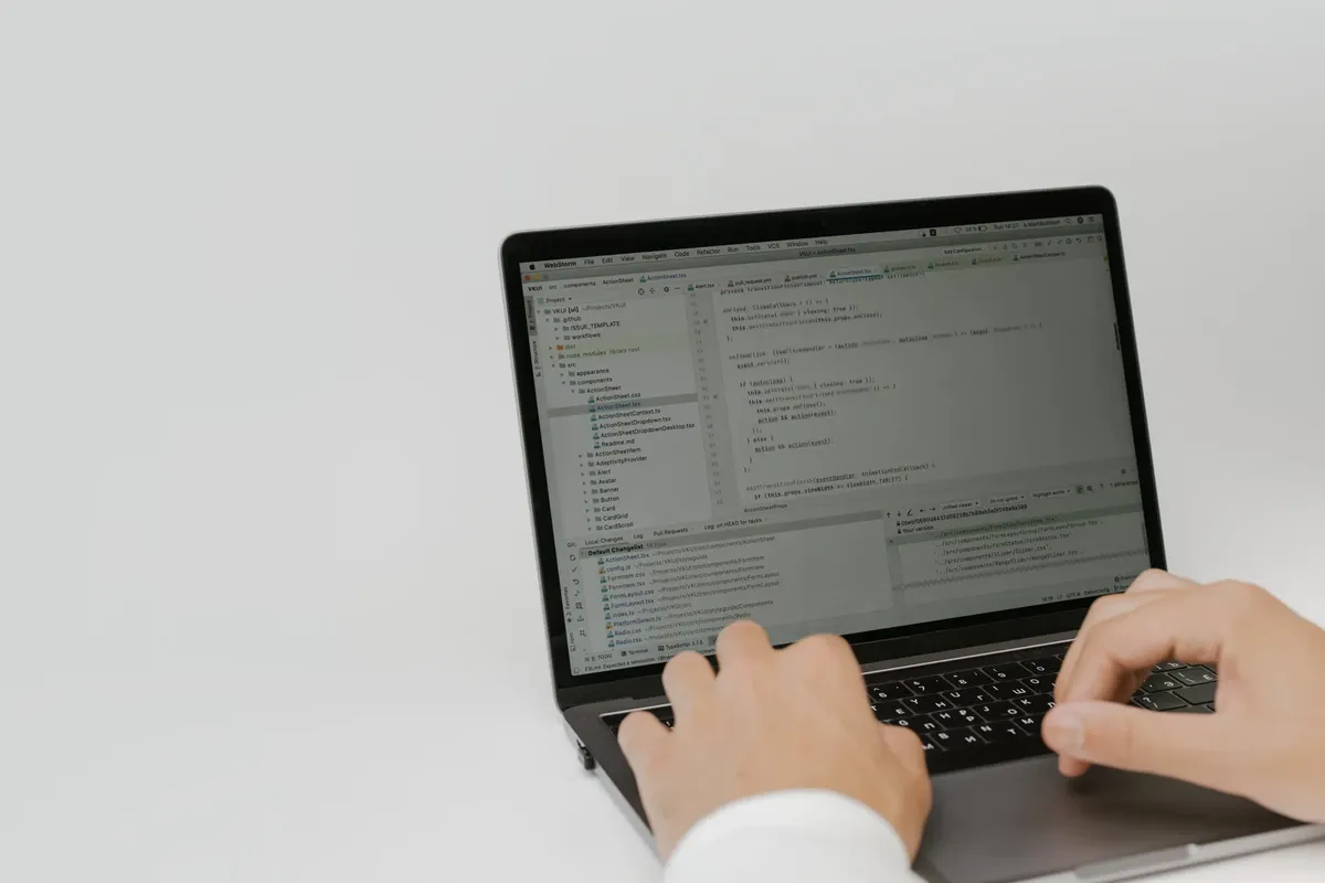 ワークスペース内のラップトップでコードを打ち込む手。室内 setting に焦点を当てたソフトウェア開発。