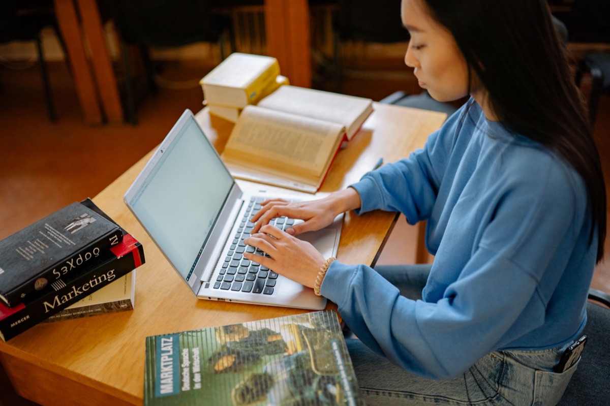 person studying with laptop and books