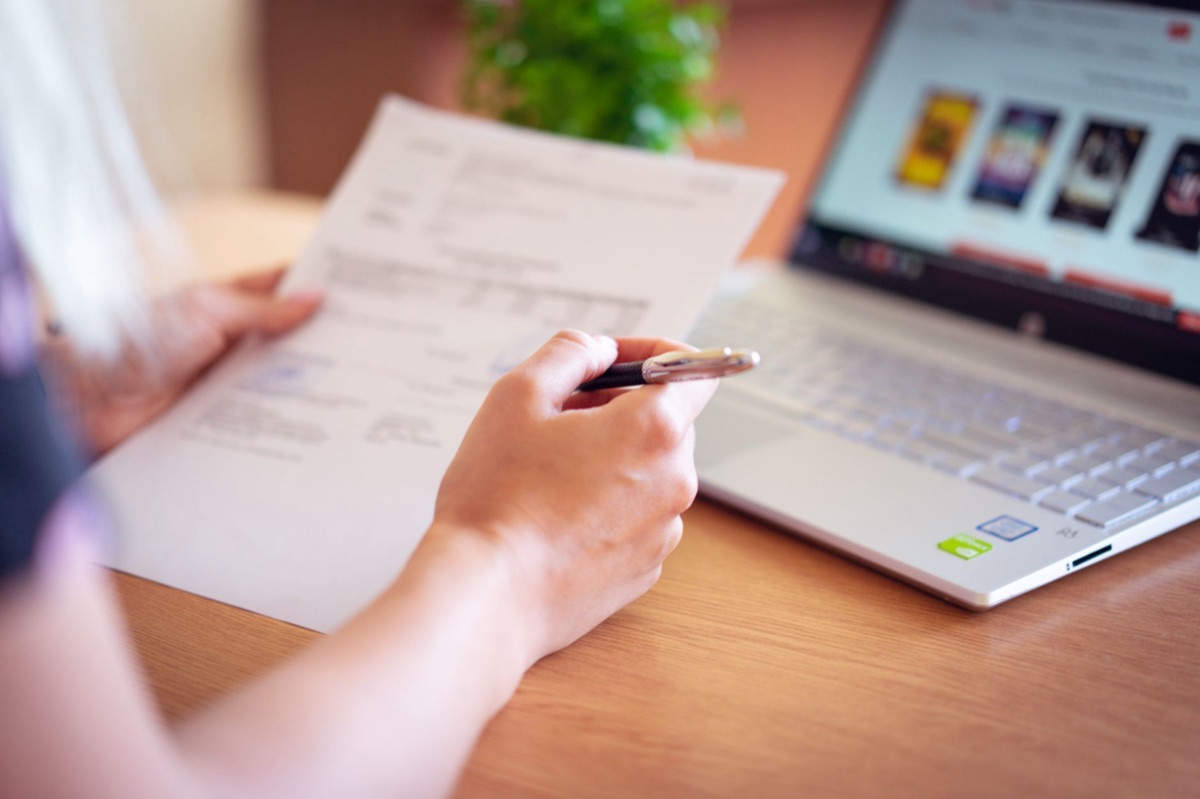 una persona che studia un documento con un laptop