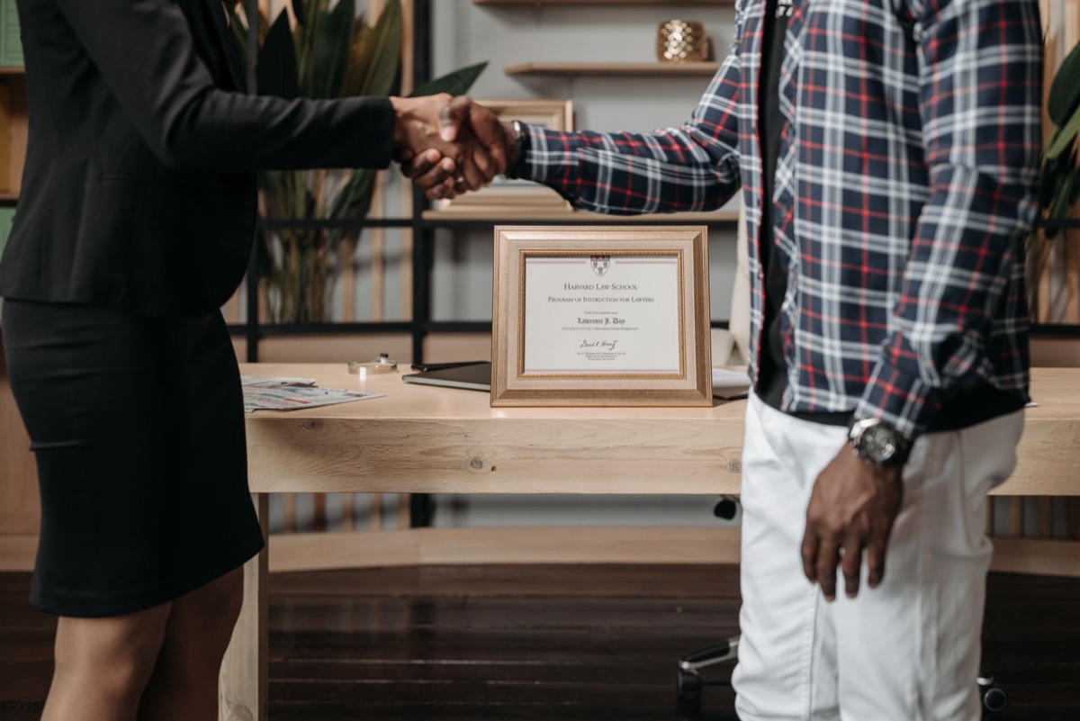 A professional certification document and a digital tablet on a desk.