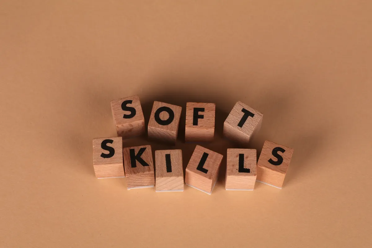 Wooden letter blocks spell out 'Soft Skills', highlighting business and personal development concepts.
